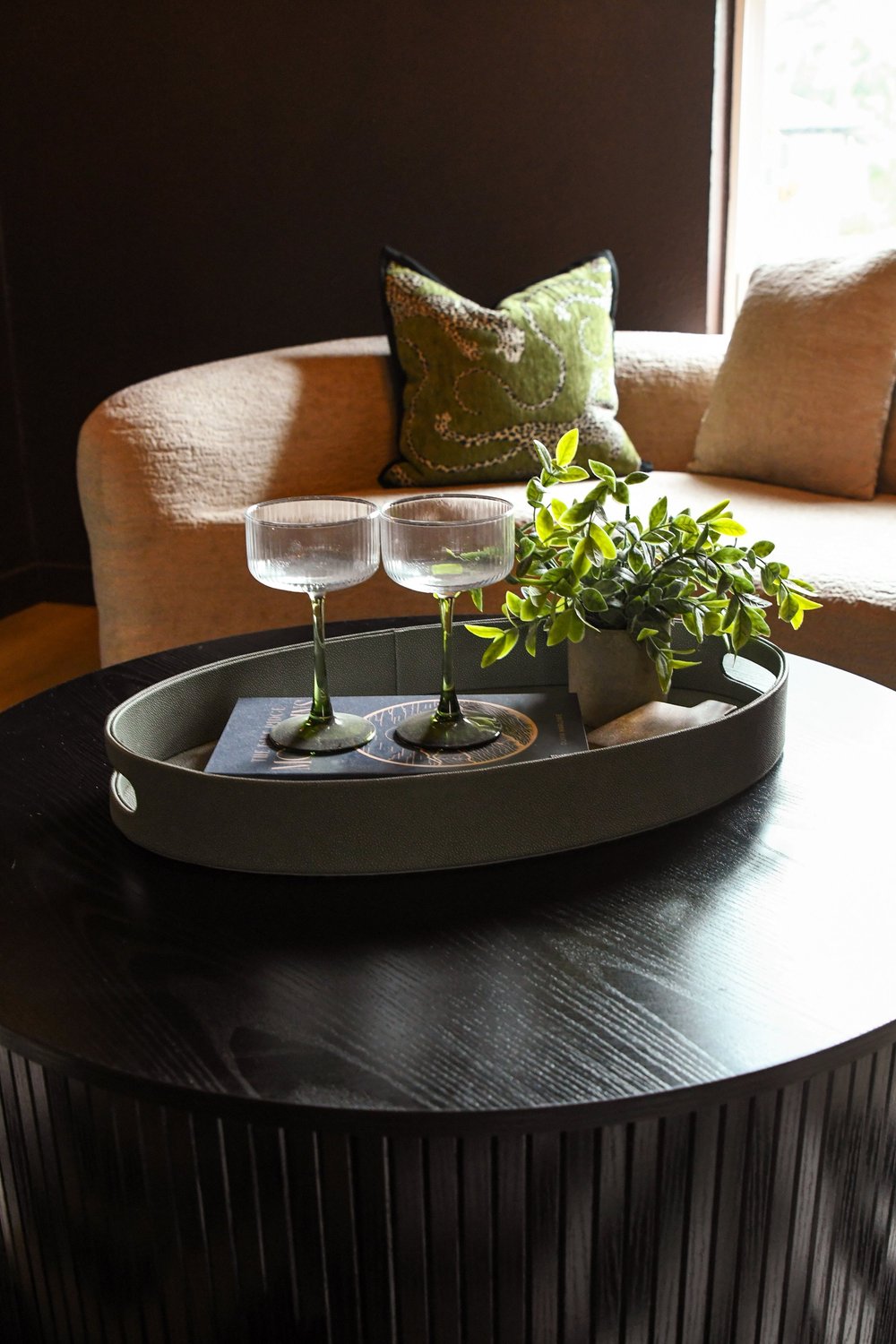 The fluted table and glass tray with the curved boucle seating behind