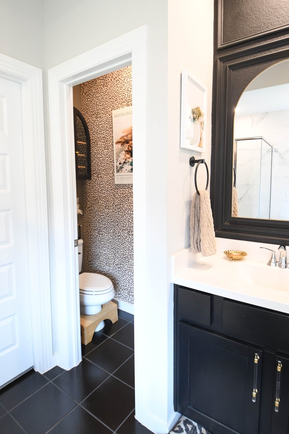 Looking from the vanity into the wallpapered water closet