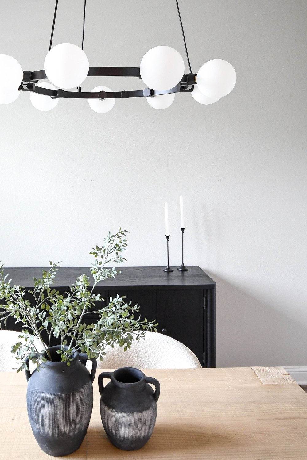 Dining room from the table with the black sideboard, candlesticks and globe chandelier