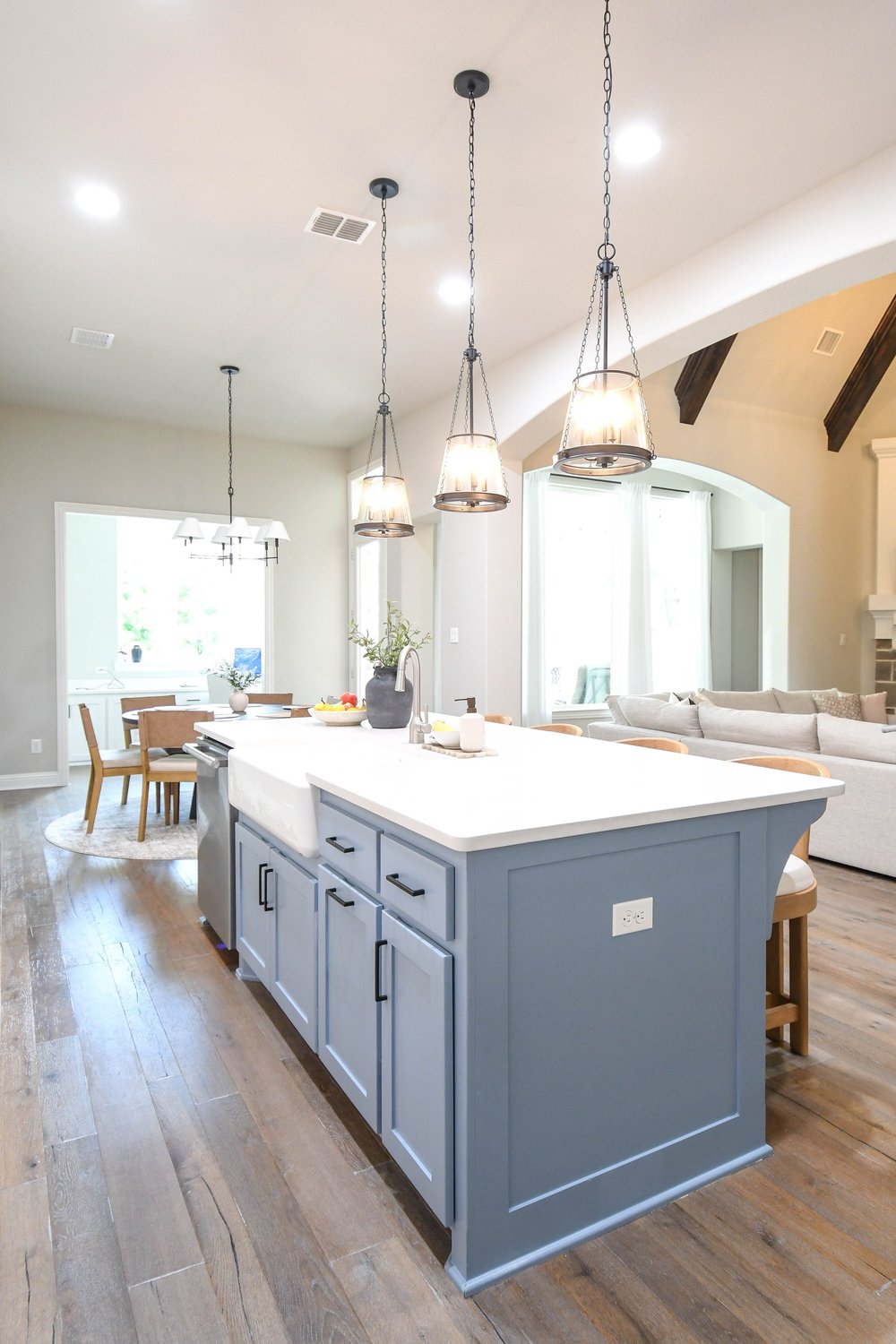 Kitchen island with a farmhouse sink seen across to the great room