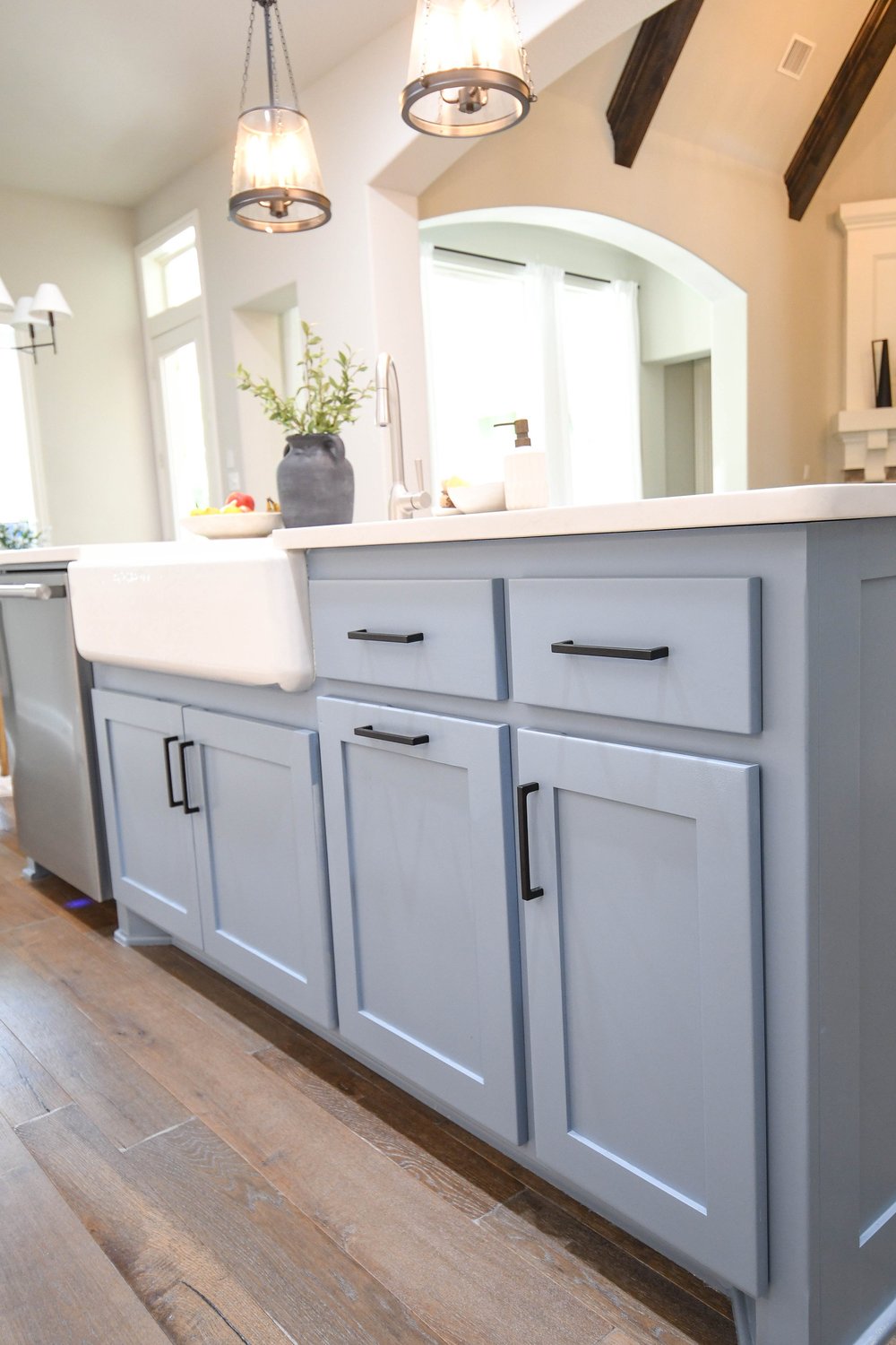 Close view of the blue grey shaker island cabinetry and apron front sink