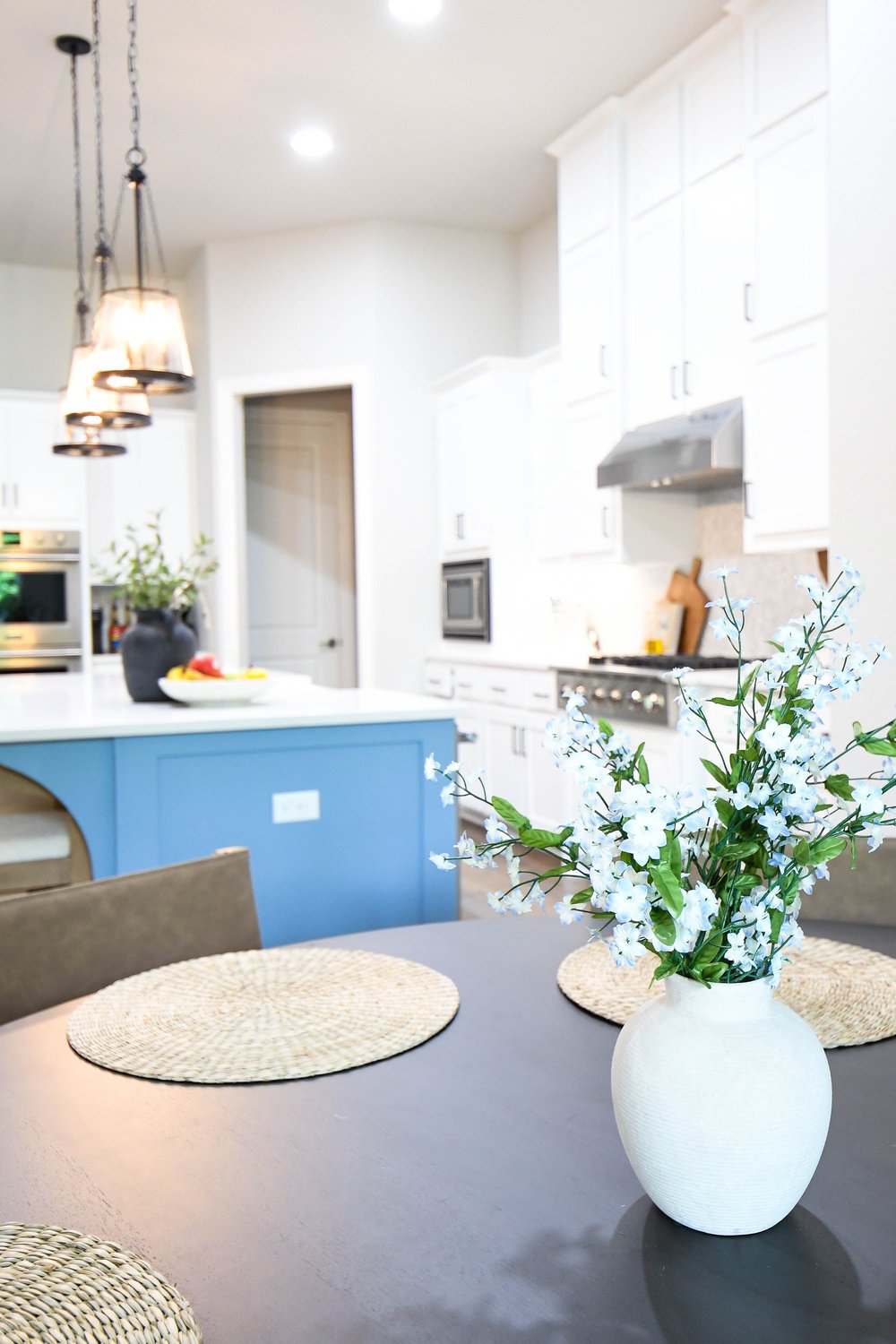 White flowers on the breakfast table with the blue island and range beyond