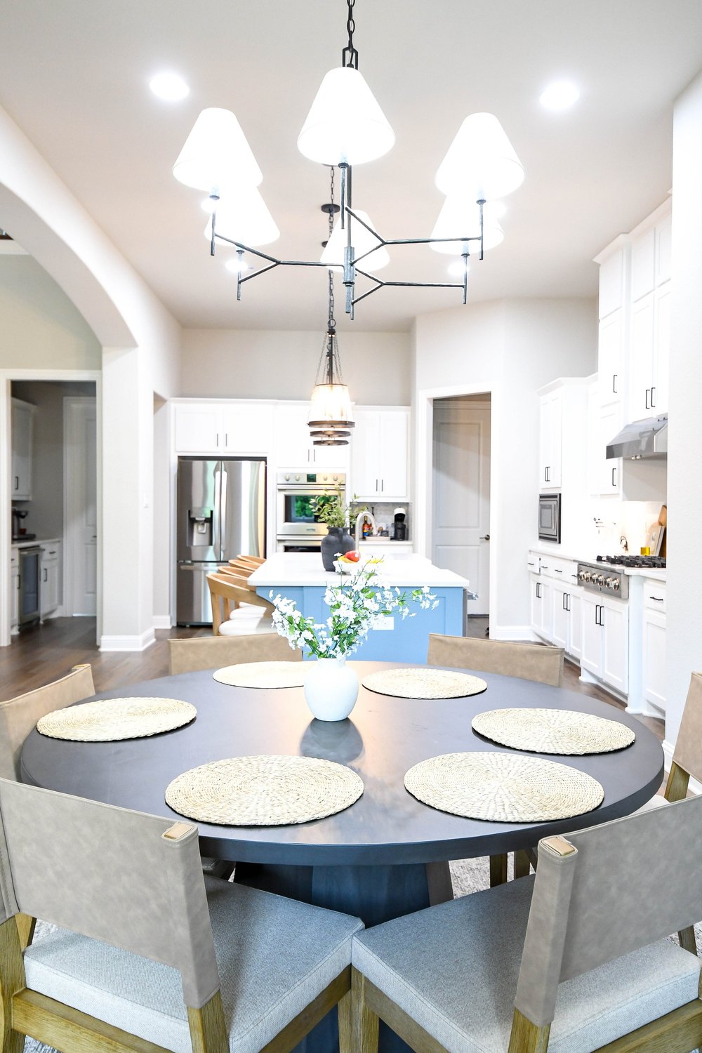The breakfast table and chandelier with the whole kitchen behind