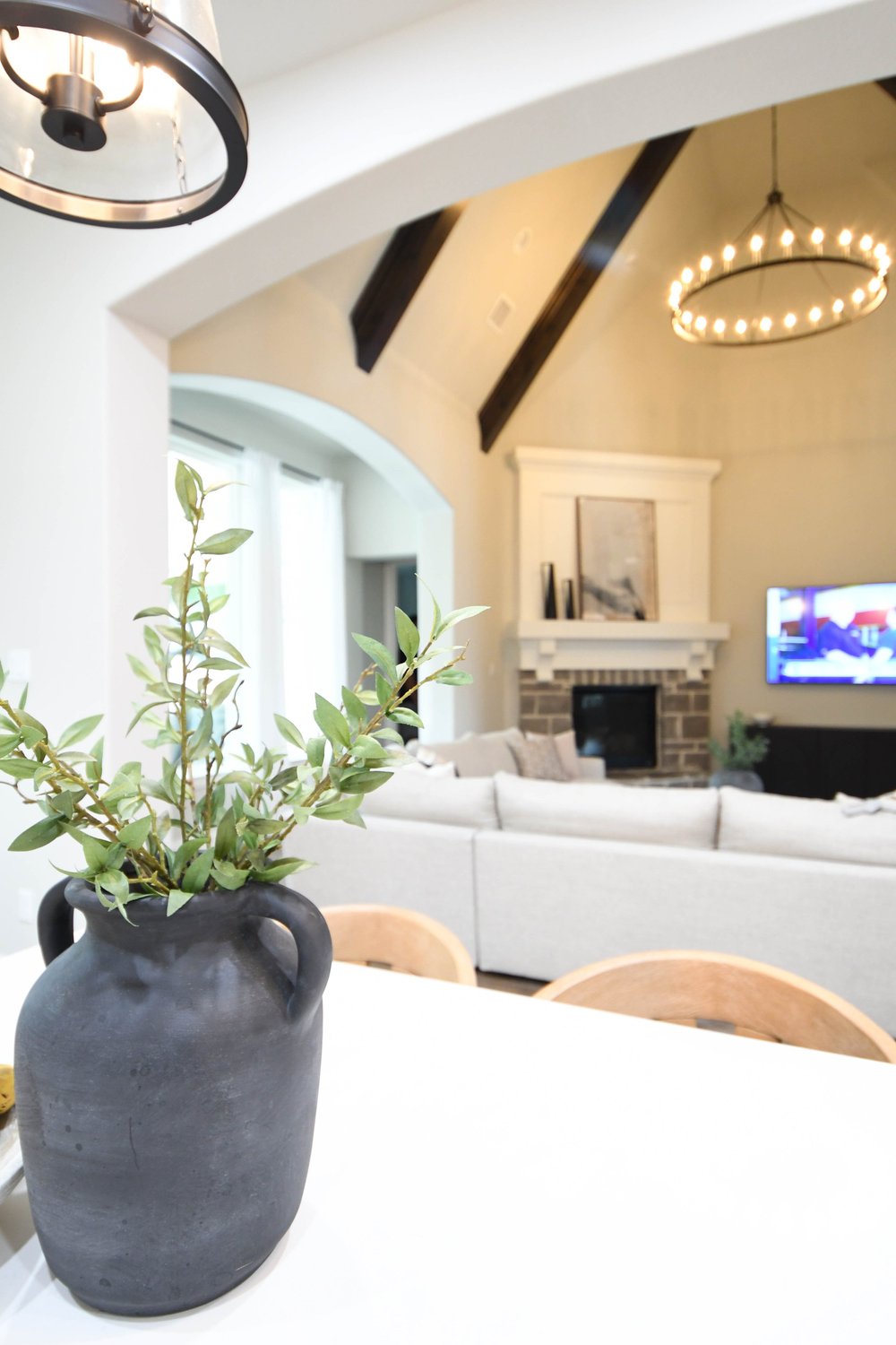 Black pottery vase on the counter with the great room and fireplace beyond