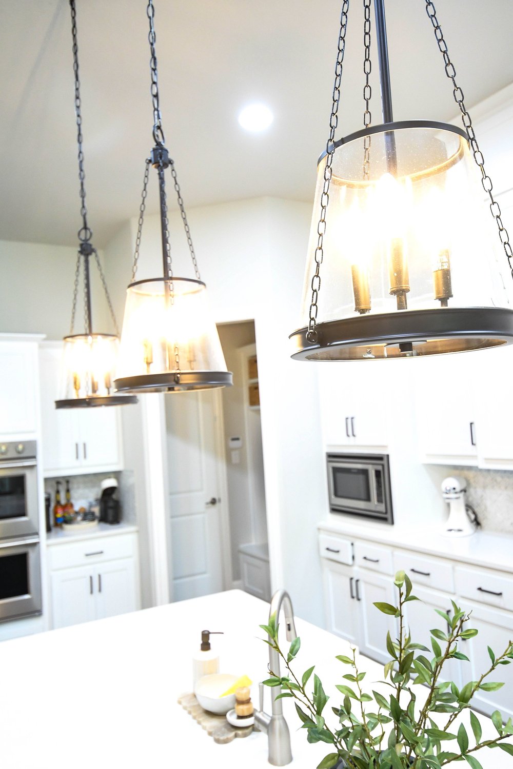 Looking up at the lantern pendants above the island toward the ovens
