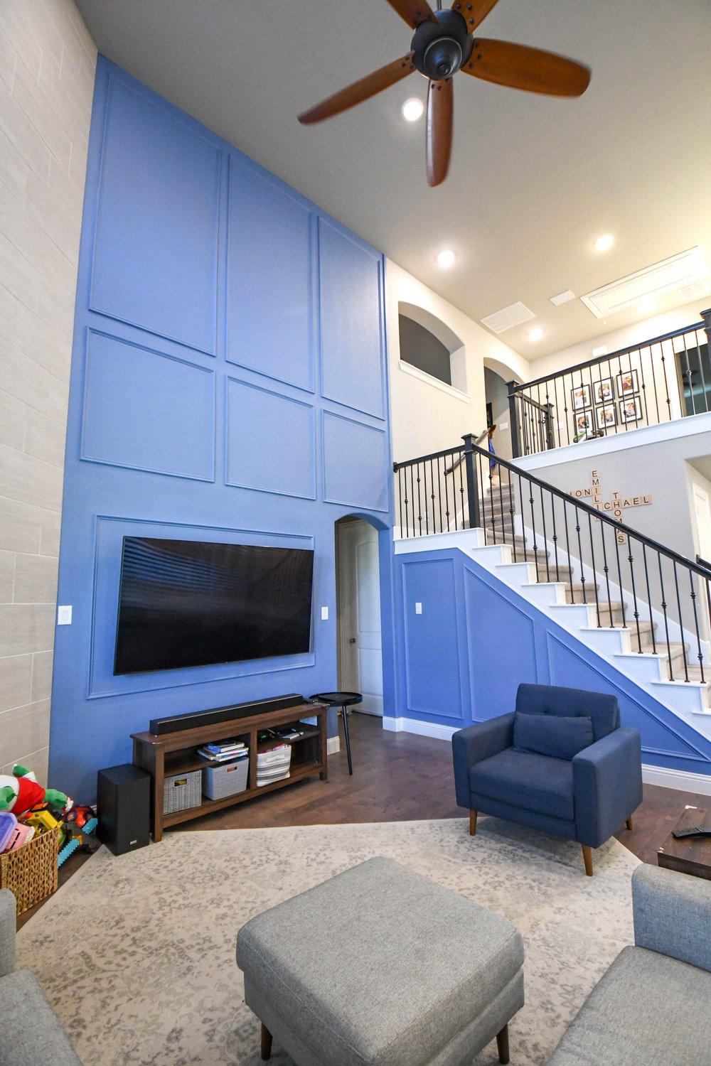 The blue accent wall and stair from the seating area with an ottoman