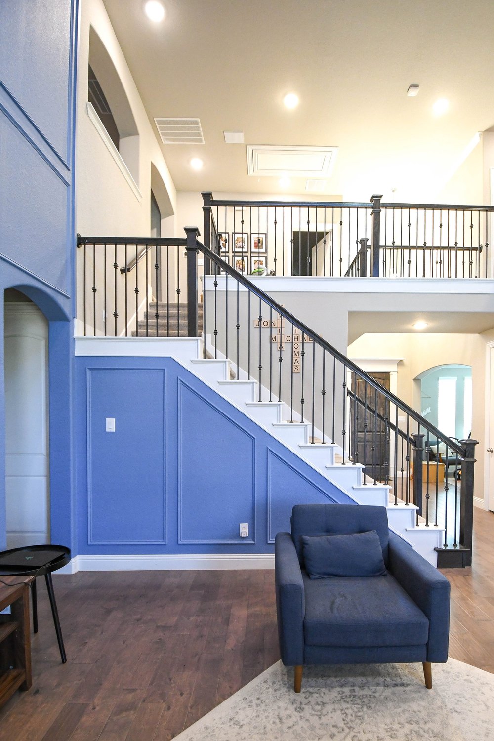 The stairway and its blue wainscot with an armchair below