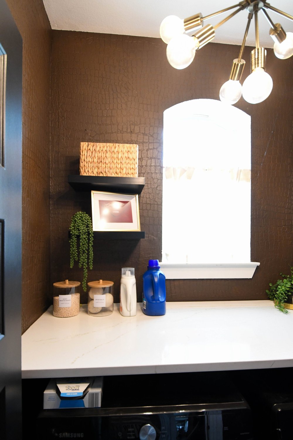 Counter with jars and detergent by the arched window