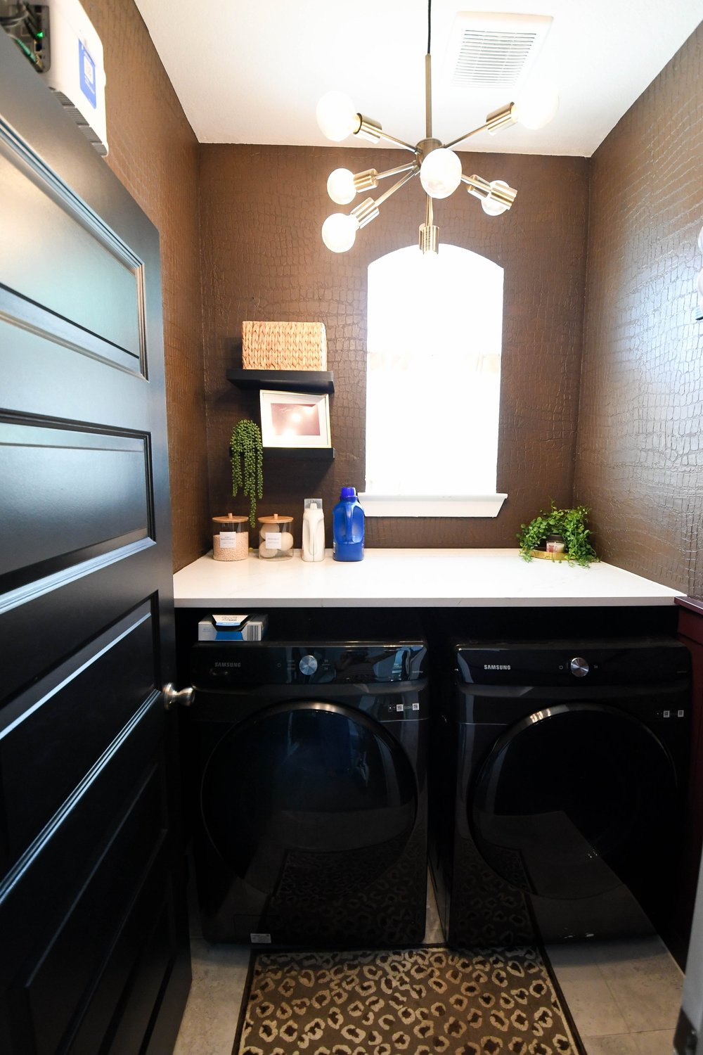 The laundry room straight on with a patterned runner between the machines