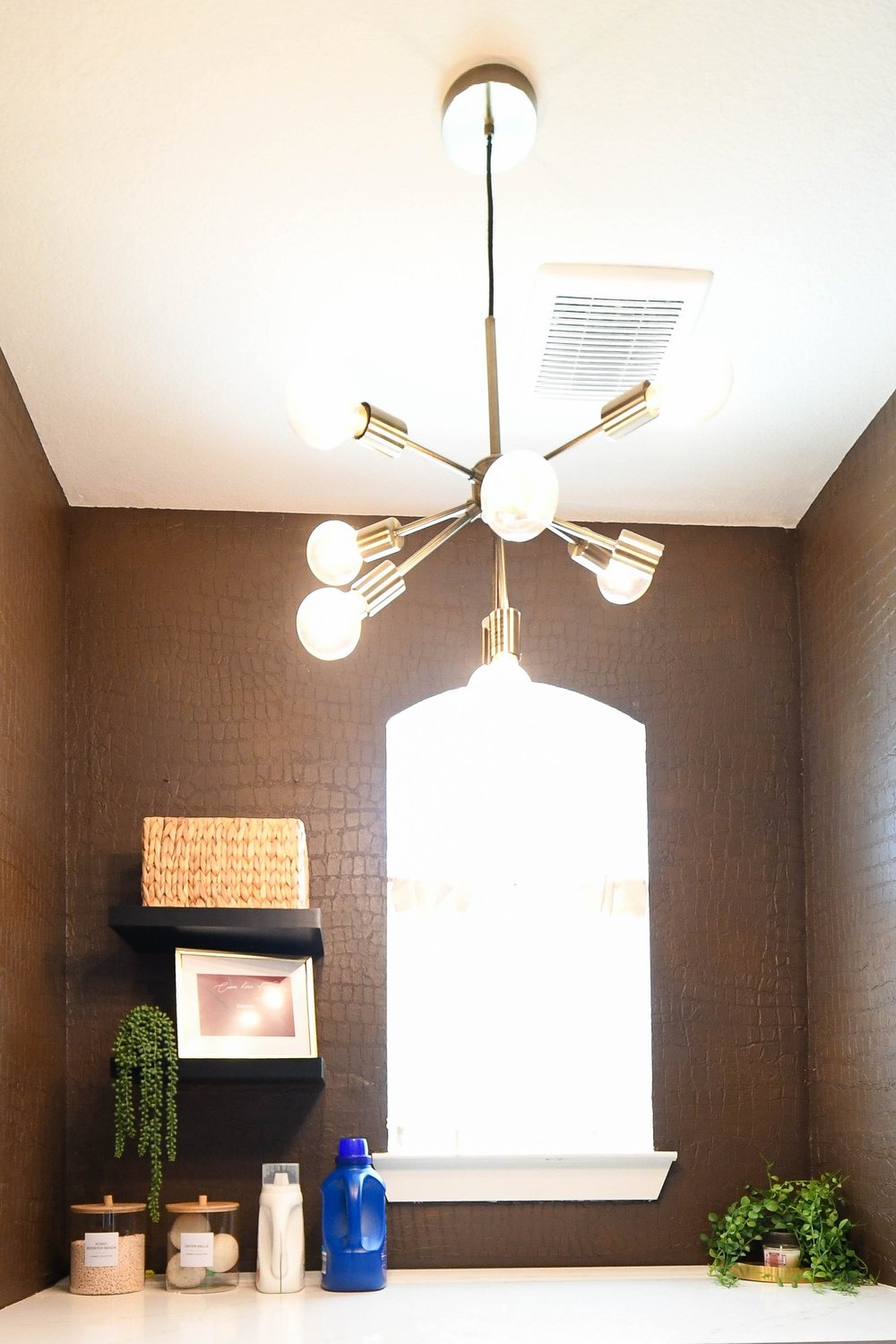 Brass sputnik fixture above the arched window and open shelf