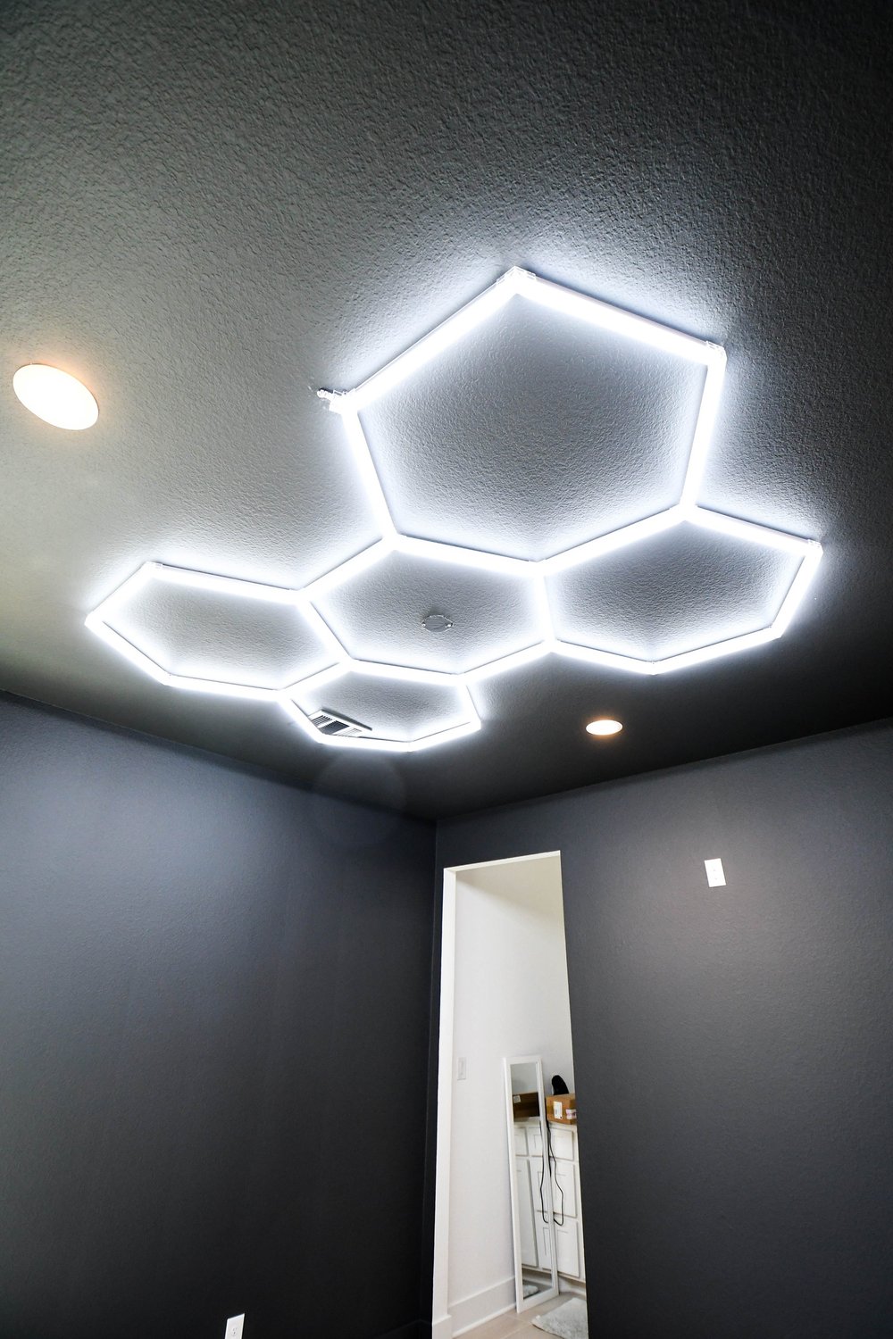 Hexagon light array on the dark ceiling above the doorway
