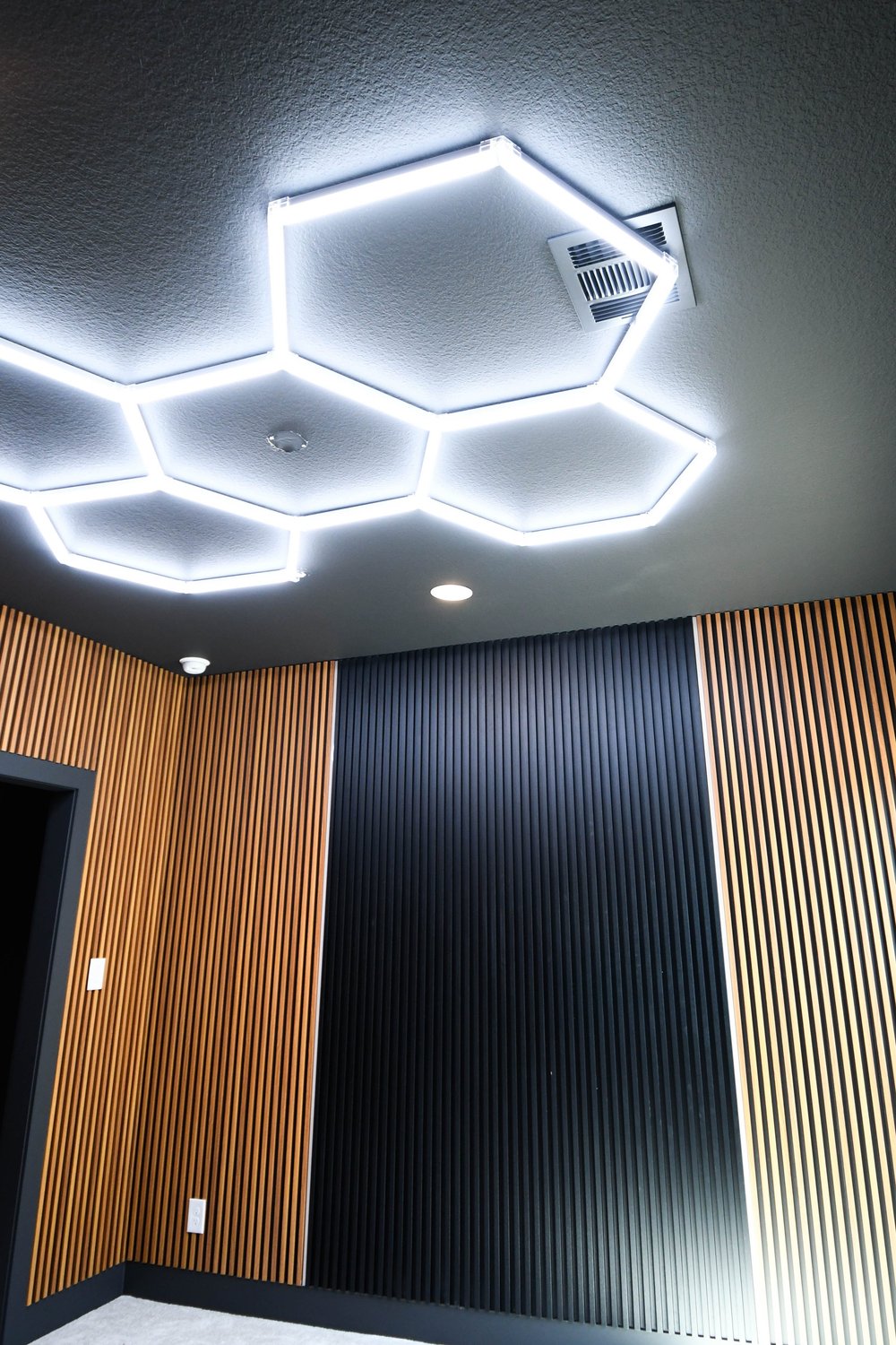 Hexagon lights above the wall's slat, flute and slat rhythm