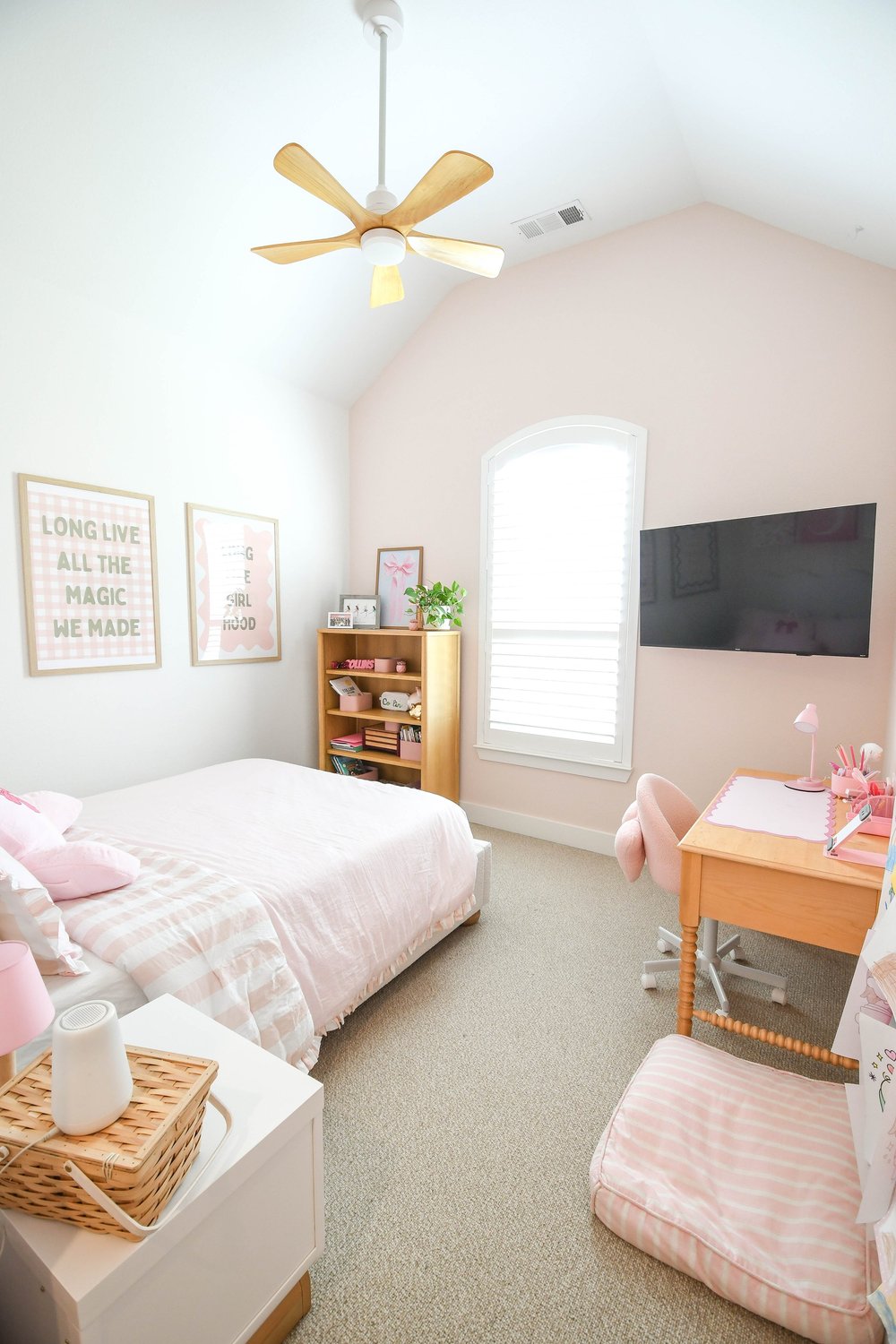 The room from the doorway with the bed, bookcase, desk and wall mounted TV