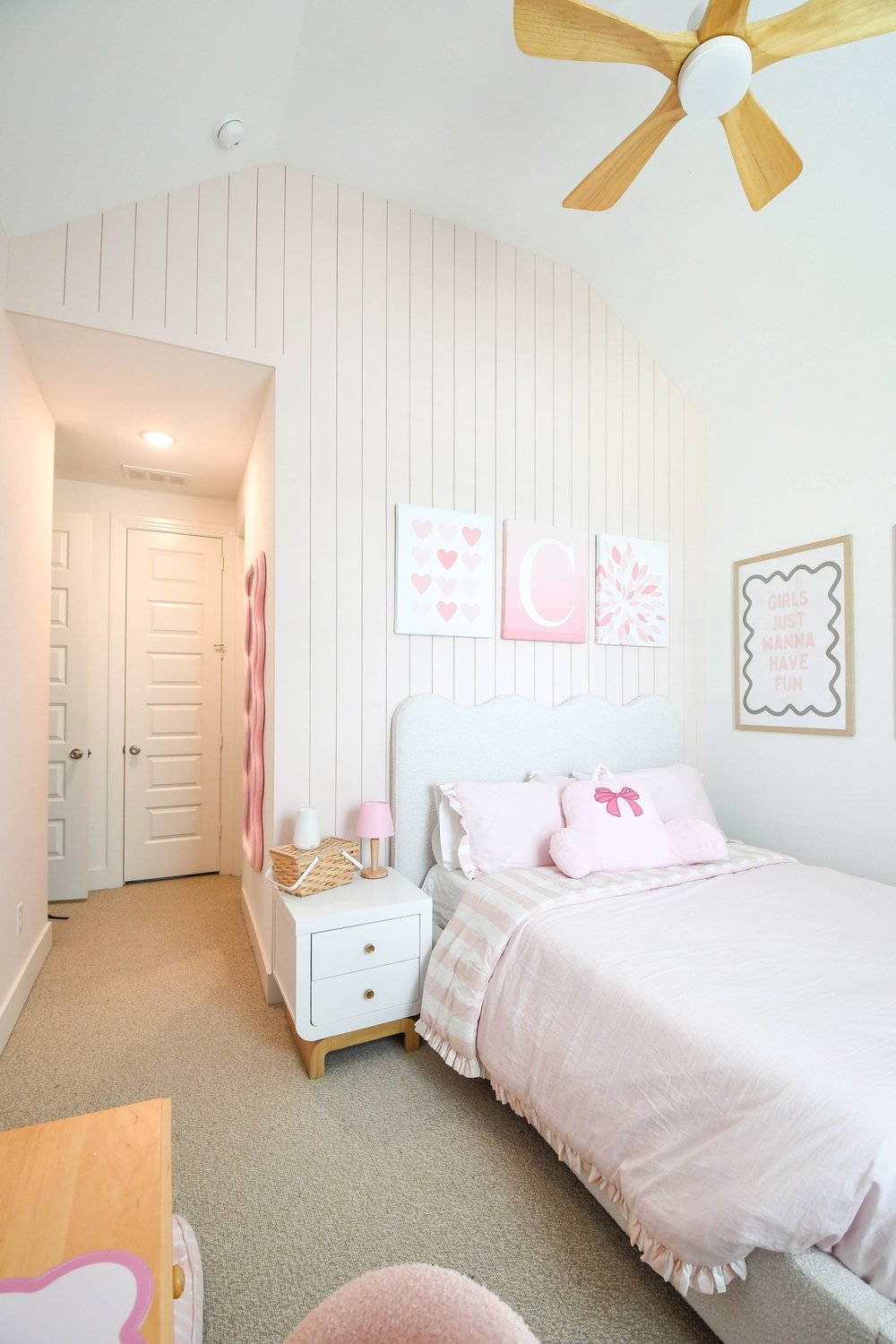 The bed and nightstand with the hallway beyond
