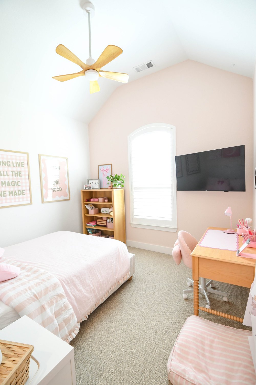 Bed, bookshelf, desk and TV under the vaulted ceiling