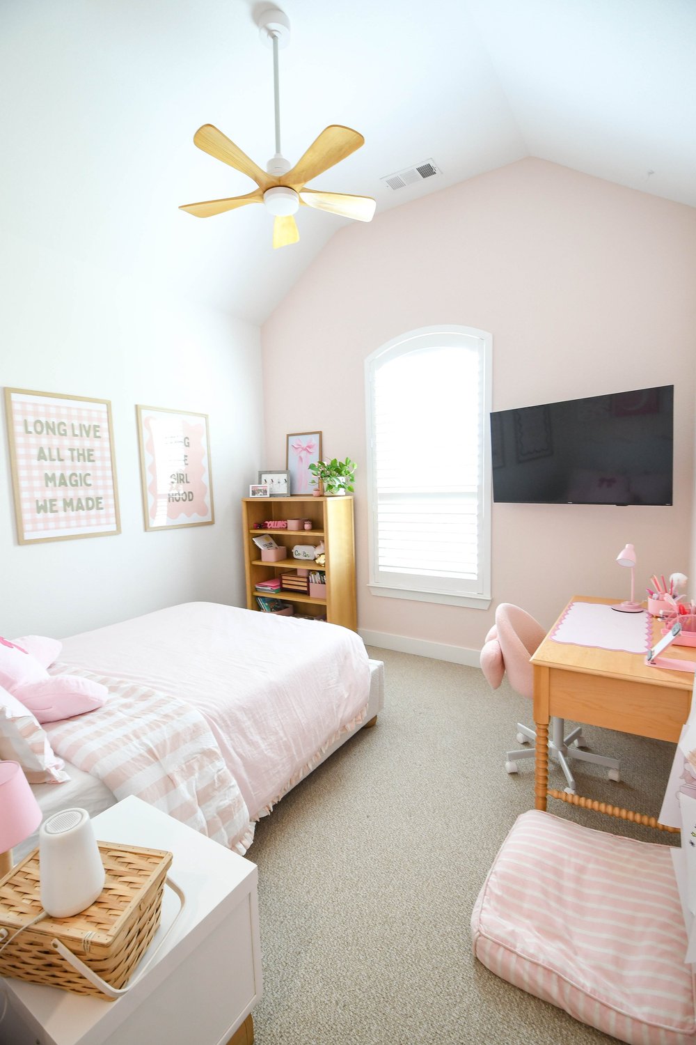 Wide view with the twin bed, bookcase, desk chair and mounted TV
