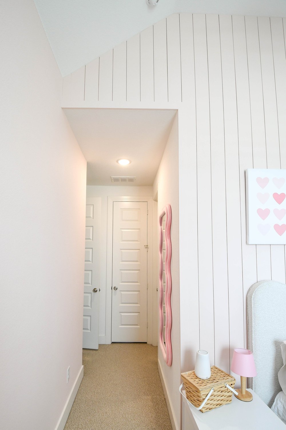Hallway to the bedroom door past the planked wall