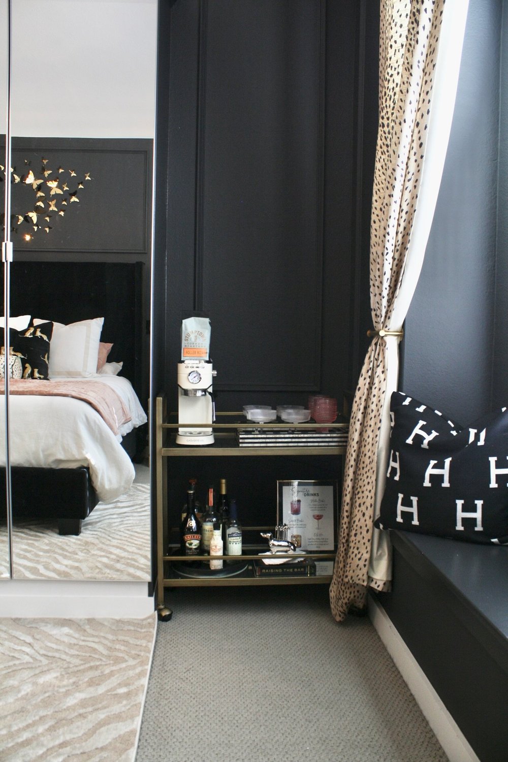 Brass bar cart beside the bed, reflected in a full length mirror