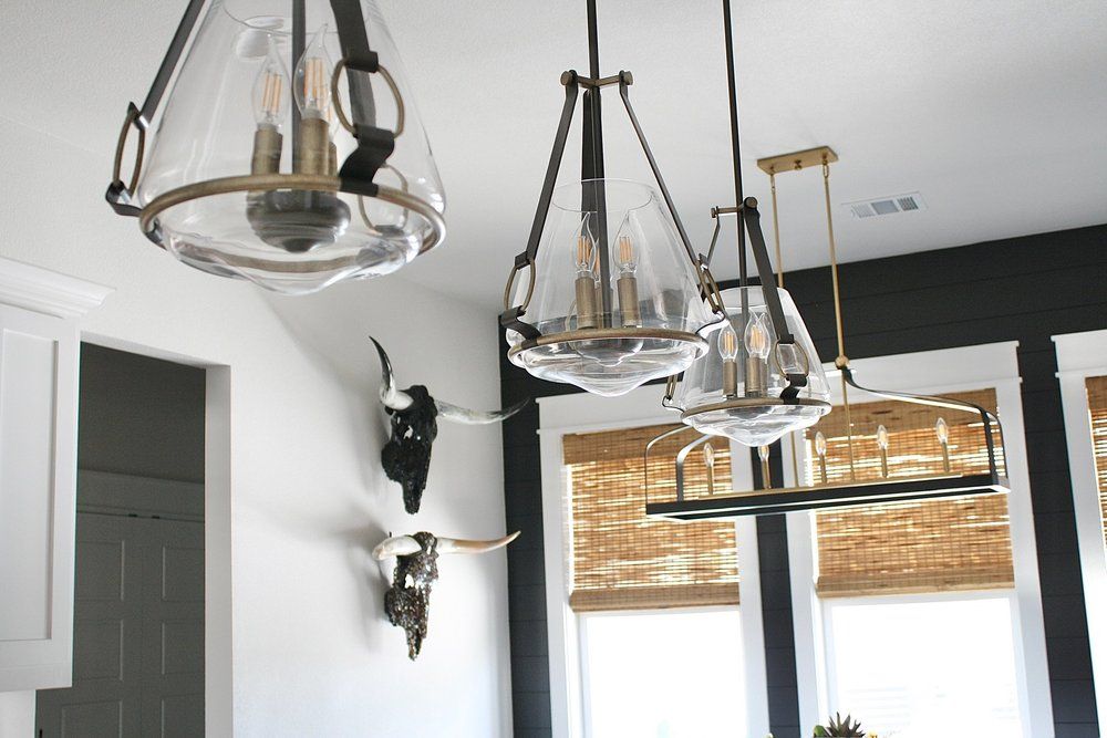Glass pendant lights and a linear chandelier below the ceiling, longhorn skulls on the wall