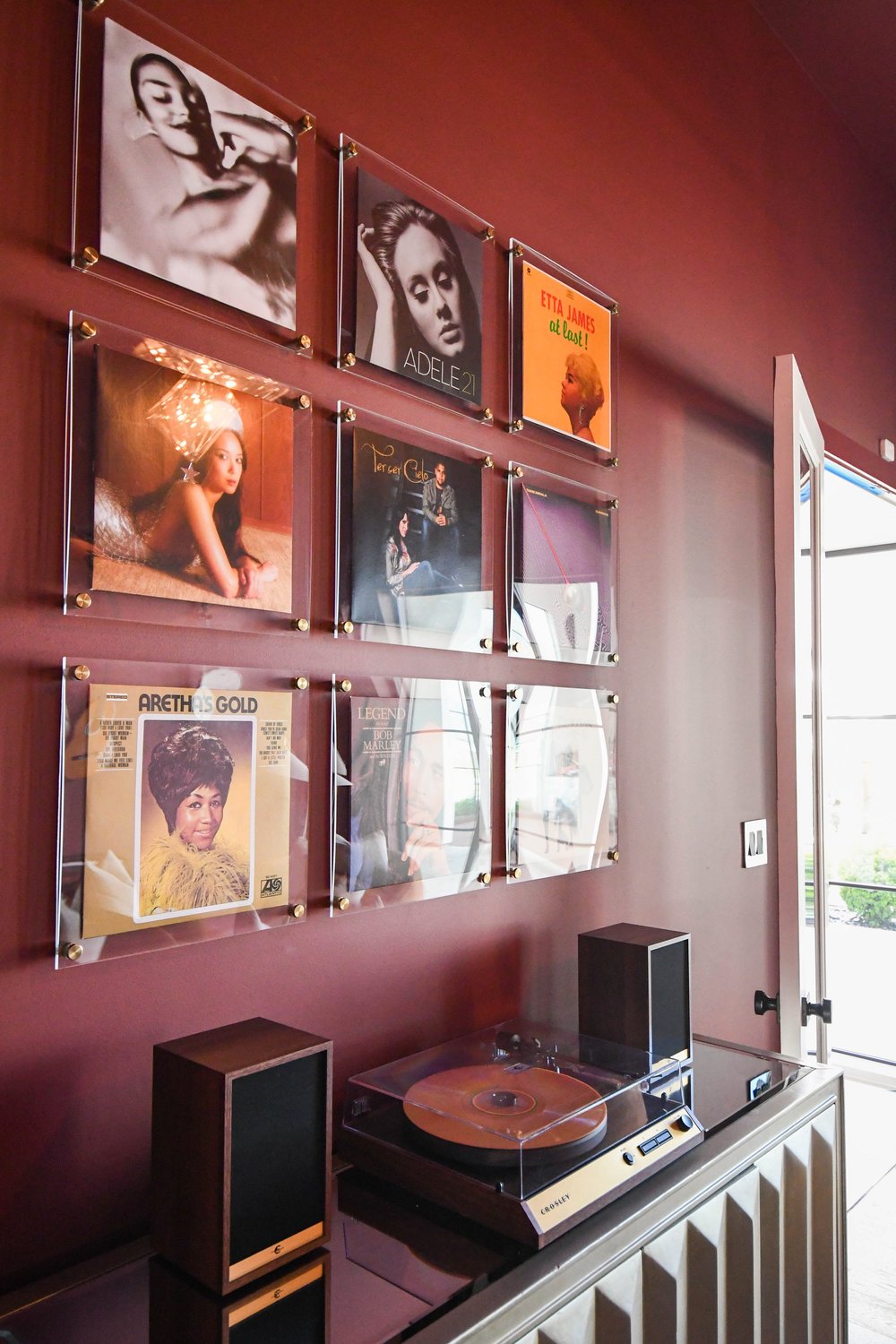 Framed record covers in acrylic frames above a turntable and speakers