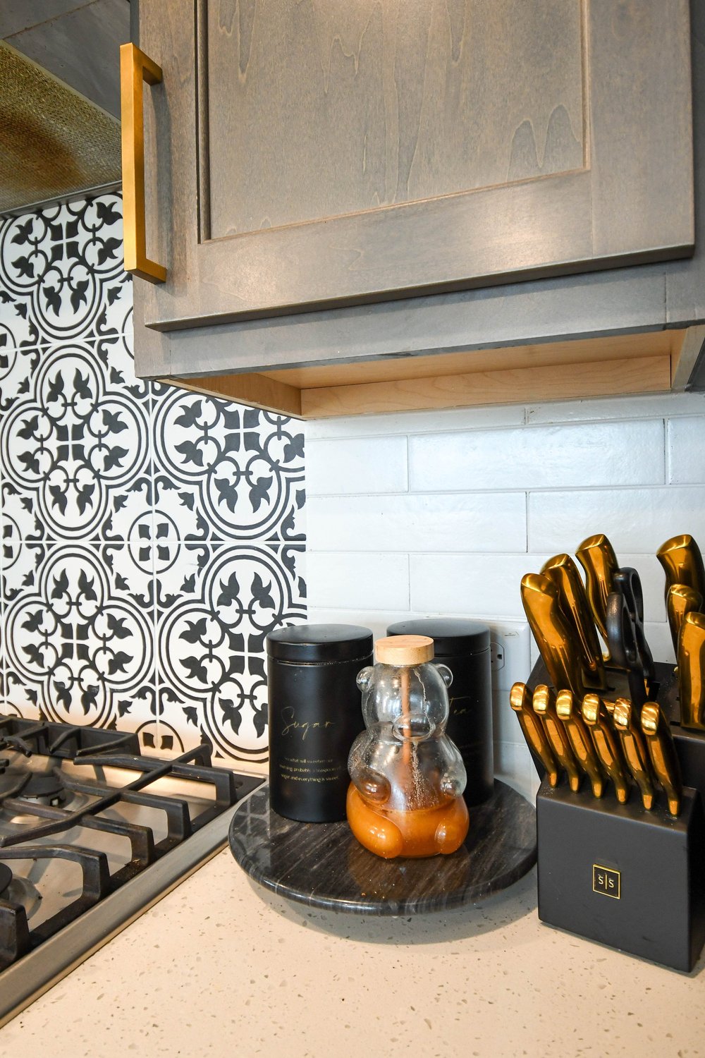 Close view of the black and white patterned backsplash beside the cooktop