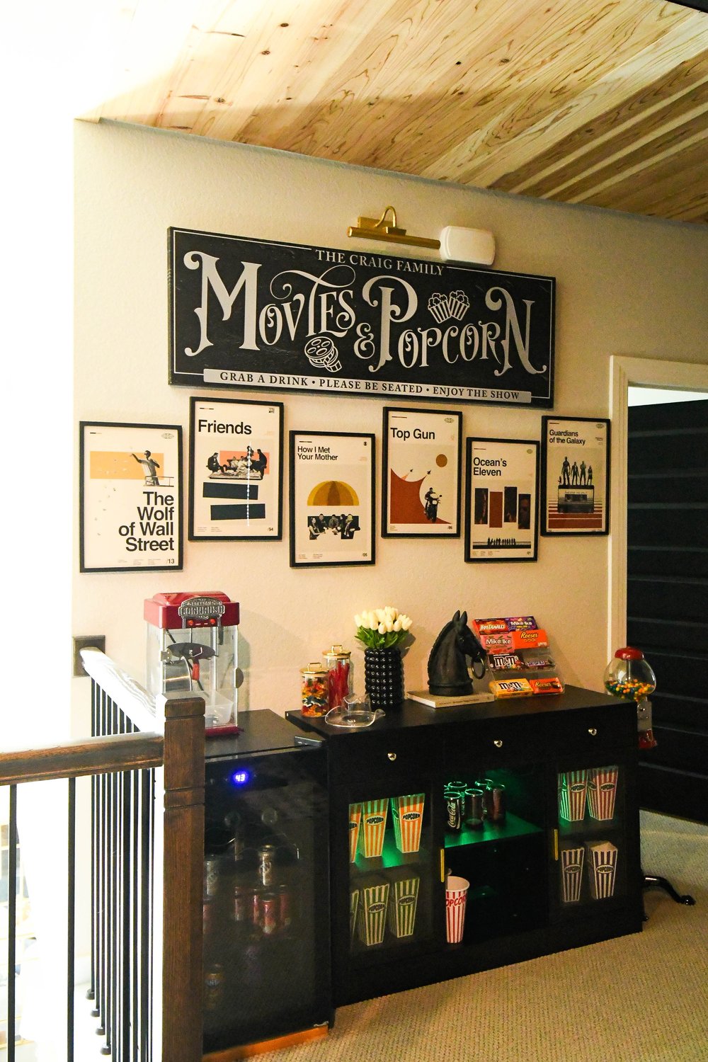 Concession cabinet with framed film posters and a Movies and Popcorn sign above