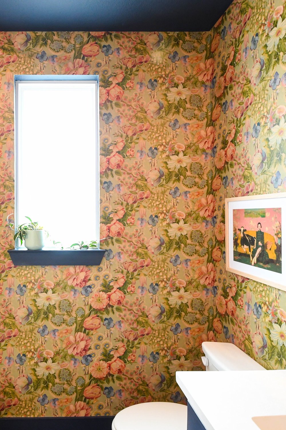 Corner of the powder room, the wallpaper carried up to the navy ceiling above a window shelf
